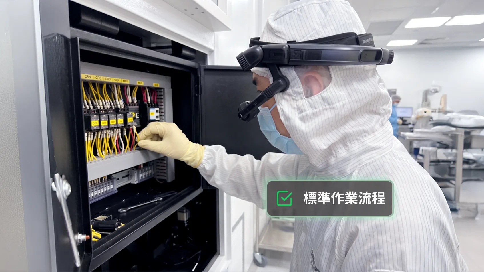 戴著智慧眼鏡與手套的無塵室技術人員正在對電控箱進行配線作業